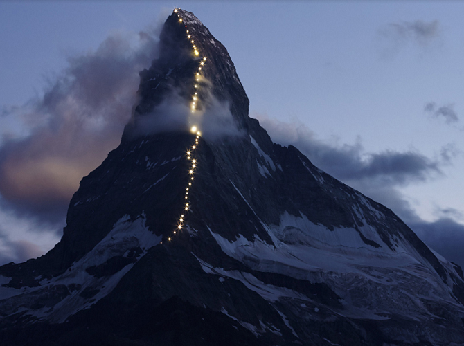 Đèn chạy bằng năng lượng mặt trời rực sáng trên đỉnh Hornli của dãy núi Matterhorn ở Zermatt, Thụy Sĩ, ngày 13/7.