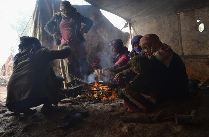 Những người Syria phải sơ tán đang sưởi ấm quanh đống lửa trong lều khi cơn bão mùa đông đang hoành hành ở làng Jabal al-Zawiya, vùng quê phía nam của thành phố Idlib, Syria ngày 7/1/2015.