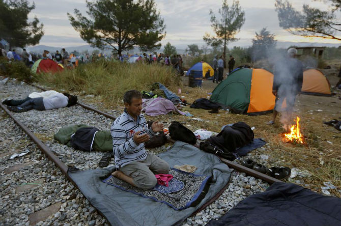 Một di dân Syria cầu nguyện ở đường tàu tại làng Idomeni, biên giới Hy Lạp – Macedonia ngày 22/8.