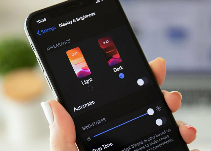 Để kích hoạt, người dùng vào Cài đặt > Màn hình & Độ sáng, sau đó chọn Tối. iOS sẽ tự động thay đổi nền đen cho tất cả ứng dụng mặc định và một số app bên thứ ba.