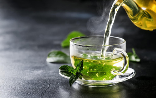2. Trà xanh. Trà xanh được đánh giá là "thực phẩm vàng" cho sức khỏe. Nghiên cứu chỉ ra, trà xanh chứa nhiều chất đặc biệt như caffeine giúp tinh thần phấn chấn, catechins – chất chống oxy hóa có tác dụng giảm cholesterol, vitamin A, E, C, B1, B2, khoáng chất giúp thúc đẩy loại bỏ natri trong máu, phòng chống bệnh cao huyết áp, flavanol giúp loại bỏ chứng hôi miệng, saponin chống viêm và nhóm axit butyric giúp giảm huyết áp.
