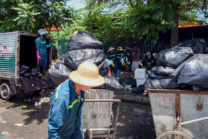 Tại một bãi tập kết rác trên đường Châu Văn Liêm (quận Nam Từ Liêm), nhóm công nhân của công ty Công ty CP Công nghệ cao Minh Quân đội nắng xử lý hàng đống rác thải bị ùn ứ từ nhiều ngày trước.