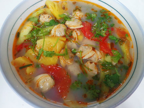Đổ nước luộc ngao đã gạn bỏ phần cặn lắng vào nồi cùng 2 quả sấu, dứa thái miếng nhỏ và gừng vào đun khoảng 10 phút. Sau đó cho ngao và cà chua bổ múi cau vào đun thêm 5 phút nữa, nêm nếm gia vị vừa ăn. Cho hành, răm, thì là vào rồi tắt bếp. Ảnh: thegioithuocgiamcan