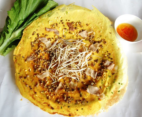 Ốc gạo, thịt trắng đục, béo thơm được rải đều trong lòng bánh. Bắc chảo lên và xoay vòng một cách nhẹ nhàng cho bột tráng đều thành một hình tròn, mép bánh không bị rách. Thêm củ sắn (củ đậu) xắt sợi và giá thêm vị ngọt cho bánh, làm cho bánh xèo ốc gạo ăn không ngấy. Ảnh: bepgiadinh