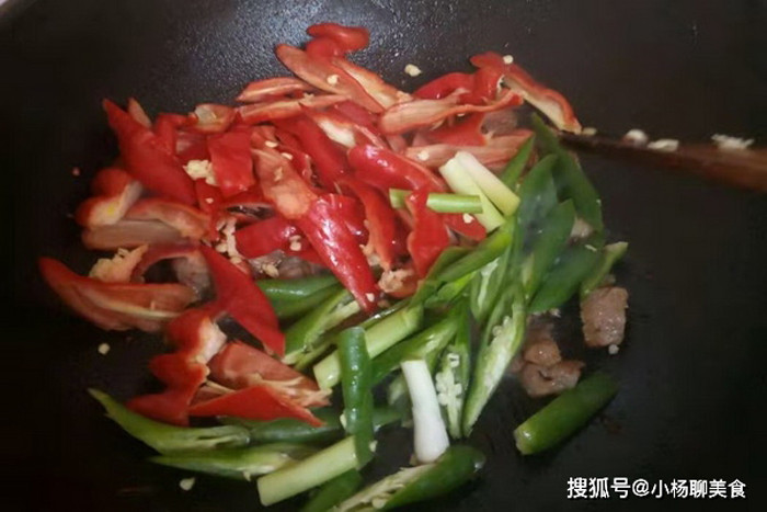Bước 4, chuẩn bị một chiếc chảo khác, làm nóng dầu. Cho thịt ướp vào, vặn lửa lớn để xào trong vòng 1 phút. Tiếp tục đổ ớt sơ chế trước đó, thêm tỏi, sả, gừng băm cùng một ít nước tương.