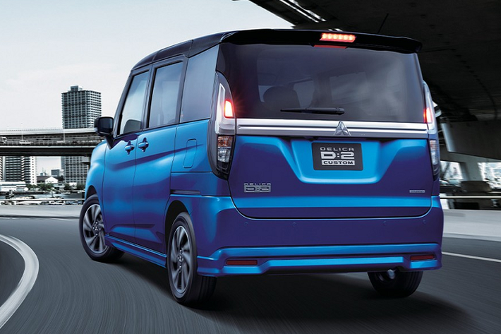Về thiết kế, Mitsubishi Delica D:2 2021 có 2 phiên bản là tiêu chuẩn và Custom thể thao hơn. Ở bản thường, mẫu xe này sử dụng lưới tản nhiệt với 3 nan mạ crôm nằm ngang. Ngoài ra, lưới tản nhiệt còn có viền mạ crôm dày dặn ở bên dưới, nối liền với cụm đèn pha hai bên. Riêng cụm đèn pha đi kèm vỏ màu tối, mang đến vẻ đẹp thanh lịch và chất lượng cao cho mẫu minivan cỡ nhỏ này. Dưới lưới tản nhiệt là hốc gió trung tâm với mắt lưới hình tổ ong. Ngoài ra, xe còn có đèn sương mù trước hình tròn, nằm trong hốc màu đen với viền mạ crôm.