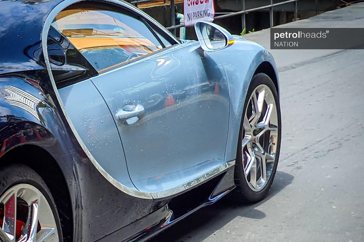 Siêu phẩm Bugatti Chiron mới về Campuchia có màu sơn 2 tông màu là bạc Liquid Silver ở nửa thân trước và nửa thân sau được hoàn thành với màu sơn xanh đậm Atlantic Blue. Chưa hết, ngoại thất xe còn có nhiều chi tiết carbon và bộ mâm mạ crôm sáng bóng của xe.
