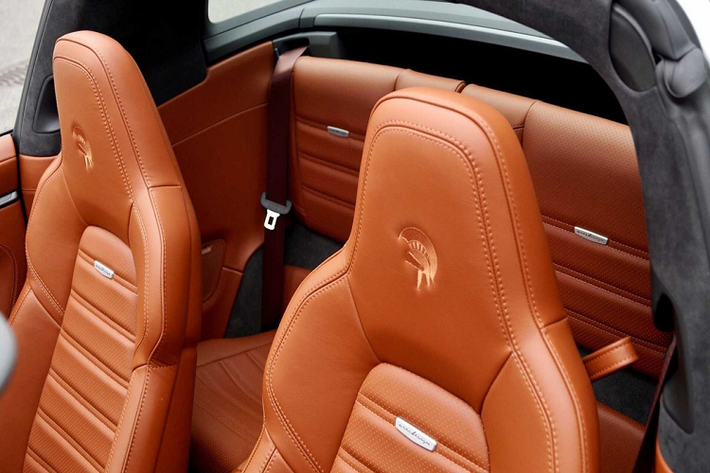 Ares Design độ Porsche 911 Targa sử dụng các chất liệu da cao cấp tại khu vực nội thất. Tựa đầu và vô lăng được thêu nổi logo vị thần chiến tranh - tên gọi của hãng độ này.