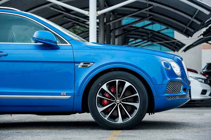 Ngay khi mở cửa xe, logo chữ B cùng viền vàng Centenary Gold sẽ phản chiếu dưới mặt đường, bên cạnh đó là 2 con số 1929-2019 được khắc trên bậc cửa xe. Chưa hết, chiếc SUV siêu sang Bentley Bentayga V8 mang màu xanh Neptune độc nhất vô nhị tại Việt Nam còn có thêm trang bị Cờ Liên hiệp Anh xuất hiện bên hông xe.