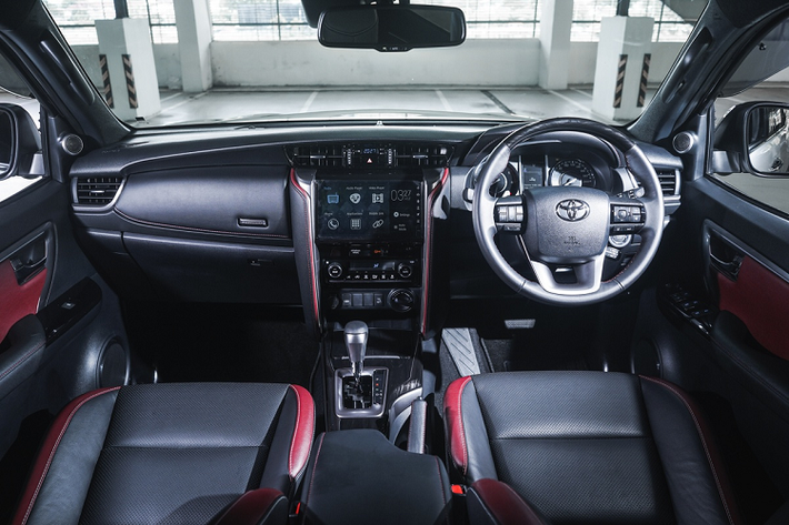 Nội thất của Toyota Fortuner được phối 2 màu đen và đỏ. Khu vực điều khiển trung tâm gồm màn hình thông tin giải trí cảm ứng 8 inch tích hợp kết nối Apple CarPlay/Android Auto, dàn âm thanh 11 loa JBL và sạc điện thoại không dây.