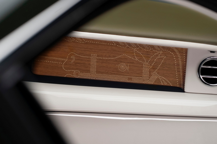 Điểm xuyết cho nội thất của Phantom Oribe của Hermes là các chi tiết gỗ óc chó Royal Walnut. Người xem đặc biệt ấn tượng bởi thiết kế đục lỗ tại các vị trí loa trên táp pi cửa.