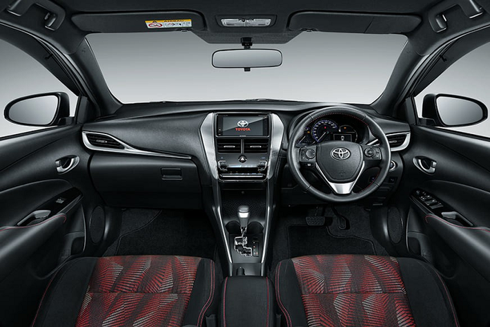 Bước vào bên trong Toyota Yaris GR Sport 2022, người lái được chào đón bằng không gian nội thất màu đen phối đỏ tương phản. Vô lăng bọc da, ghế bọc nỉ, bệ tì tay trung tâm và mặt cửa đều đi kèm chỉ khâu màu đỏ. Thêm vào đó là màn hình cảm ứng 7 inch của hệ thống thông tin giải trí, hỗ trợ kết nối với điện thoại thông minh qua Apple CarPlay và Android Auto.