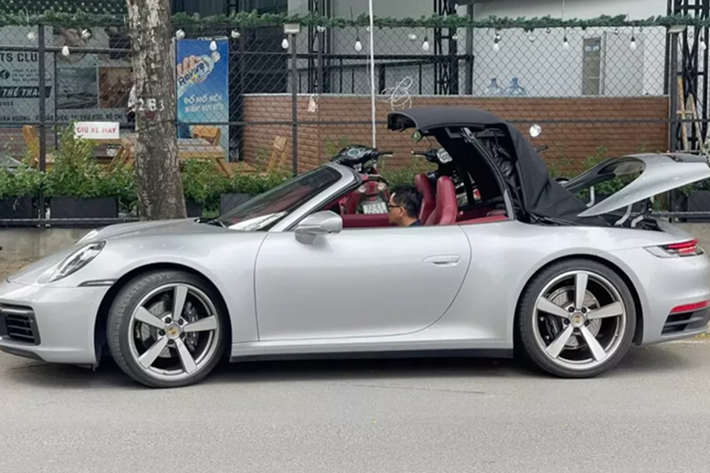 Chiếc xe thể thao mui trần Porsche 911 Carrera S Cabriolet của Thái Công đặt mua chính hãng, xe có màu xám, mui đen và nội thất đỏ đẹp mắt.
