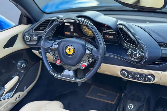 Nội thất chiếc siêu xe mui trần Ferrari 488 Spider này có màu kem, đi kèm nhiều sọc màu xanh, và lưng ghế carbon. Trước mặt ghế phụ có 1 màn hình nhỏ thể hiện tốc độ cùng nhiều thông số khác.