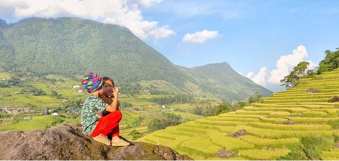Hai em bé người Mông ngồi trên mỏm đá nằm trên phần ruộng của gia đình. Ở đây, việc canh tác khá vất vả do địa hình đồi núi, chia cắt. Thế nên, mỗi vụ mùa đến, trẻ con người già đều phấn khởi nhất là khi vụ mùa bội thu. Đó là những thành quả lao động của họ sau những ngày làm việc vất vả trên nương, rẫy.