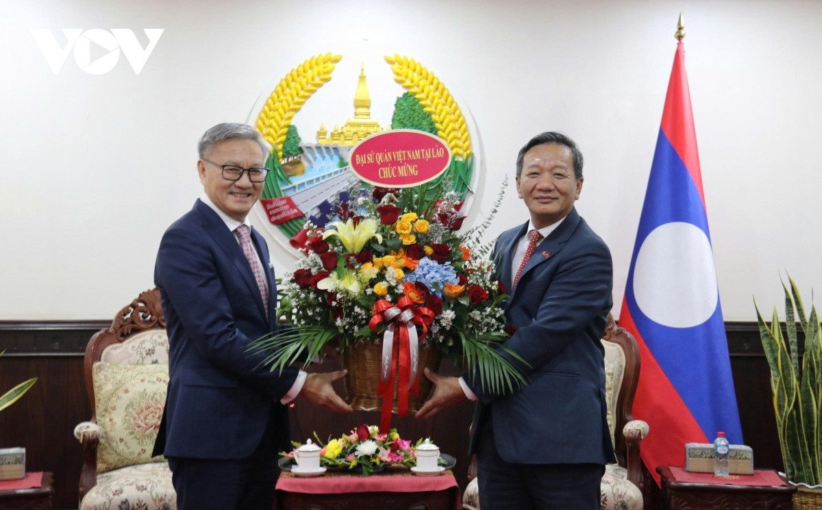 Đại sứ Nguyễn Minh Tâm (phải) gửi lẵng hoa tươi thắm chúc mừng Bộ trưởng Ngoại giao Lào nhân dịp Quốc khánh