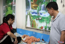 Chị Hoàng Thị Xoan ở xóm Nam Chiến Thắng cùng đứa con chưa đầy tháng tại vị trí tránh trú bão của Trường Tiểu học Diễn Bích, xã Diễn Châu. Ảnh: Thanh Hải