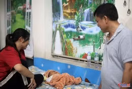 Chị Hoàng Thị Xoan ở xóm Nam Chiến Thắng cùng đứa con chưa đầy tháng tại vị trí tránh trú bão của Trường Tiểu học Diễn Bích, xã Diễn Châu. Ảnh: Thanh Hải