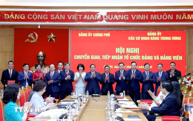 Thường trực Ban Bí thư Trần Cẩm Tú, Thủ tướng Phạm Minh Chính, đại diện Đảng ủy Chính phủ, Đảng ủy các cơ quan Đảng Trung ương và các đảng bộ chuyển giao, tiếp nhận chụp ảnh chung. (Ảnh: Phương Hoa/TTXVN)