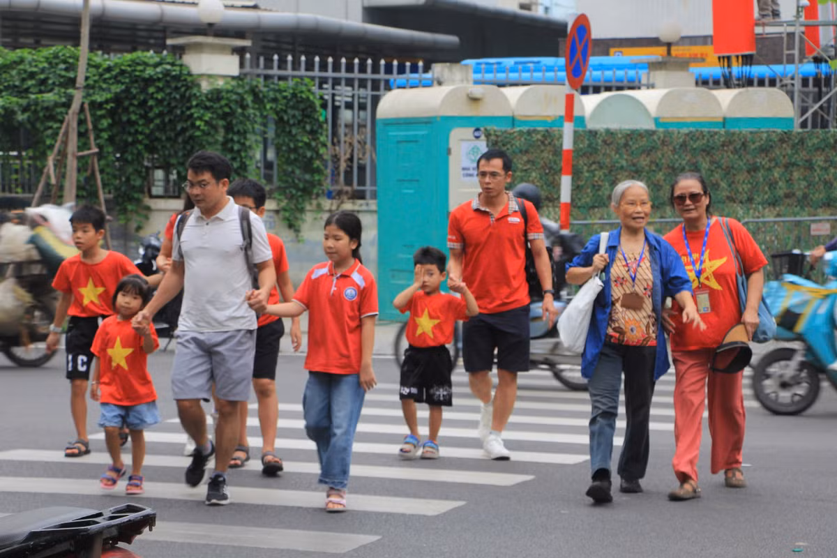 Các em nhỏ trong sắc áo cờ đỏ sao vàng cũng háo hức đi xem hợp luyện.