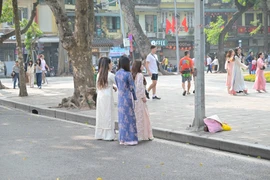 Hồ Gươm tấp nập các 'nàng thơ' xúng xính đi chụp áo dài đón Tết