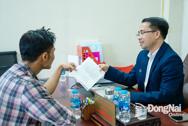 Luật sư Trương Hồng Kỳ (Đoàn Luật sư tỉnh Đồng Nai, phải) tư vấn pháp lý về thuế cho một chủ hộ kinh doanh. Ảnh: Lê Duy dy652emm.png