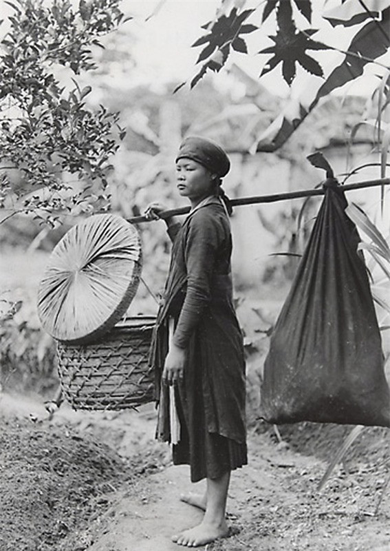 Một người phụ nữ với đòn gánh trên vai.