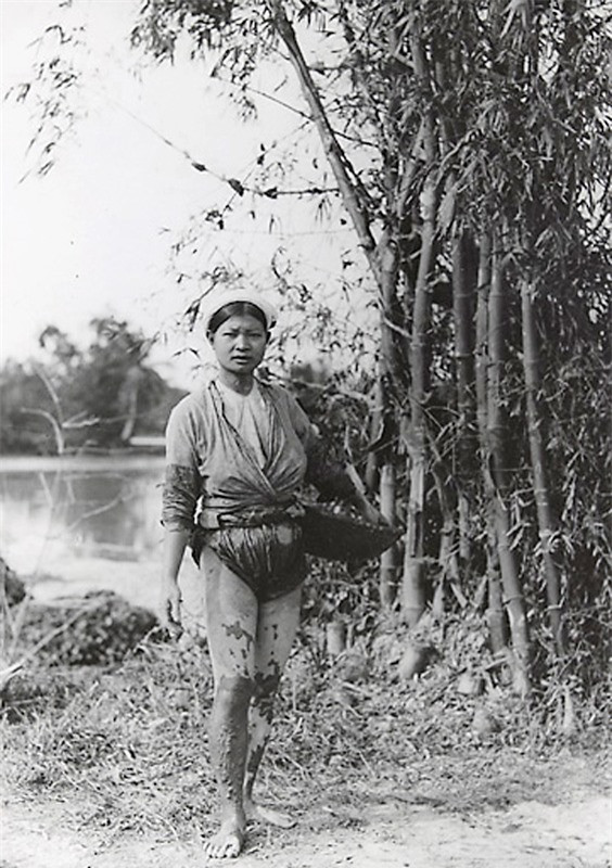 Thôn nữ chân lấm tay bùn bên bụi tre.