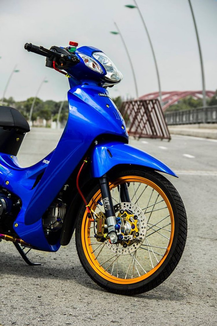Thay vì vành nan sắt nguyên bản, chiếc Wave 125 đã được chủ xe nâng cấp lên niềng nhôm nhẹ hơn, có màu vàng nổi bật cùng bộ căm sáng bóng.