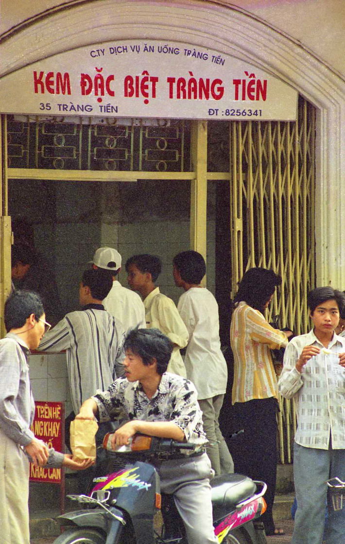 Bên ngoài cửa hàng "Kem đặc biệt Tràng Tiền" trên phố Tràng Tiền, Hà Nội năm 1998. Ra mắt từ năm 1958, kem Tràng Tiền là một trong những thương hiệu ẩm thực nổi tiếng bậc nhất của Hà Nội. Ảnh: Yuichi Kobayashi.