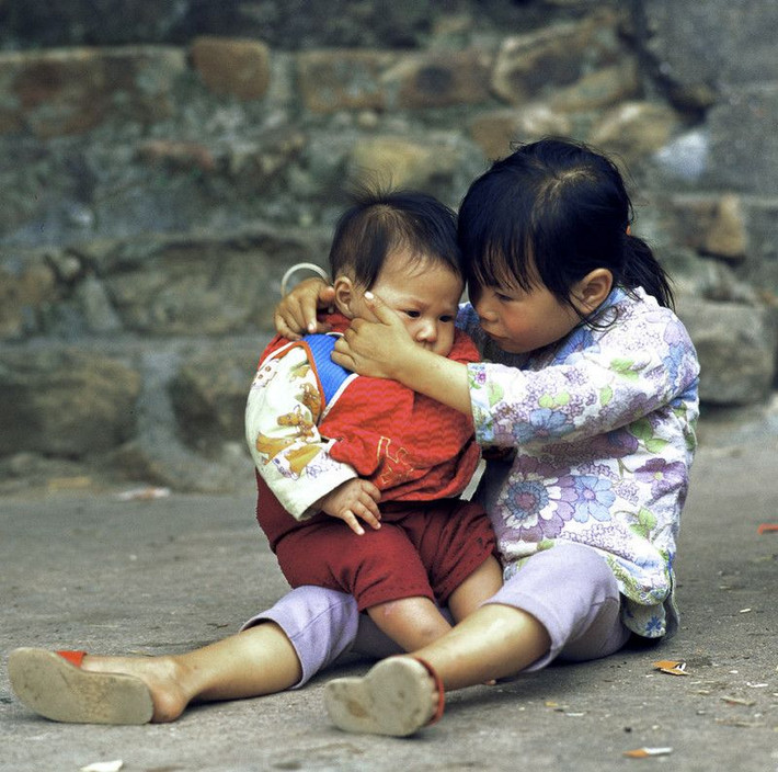 Bé gái chăm sóc em trai mình, đảo Kao Sai Chau, 1978. Ảnh: Keith Macgregor.