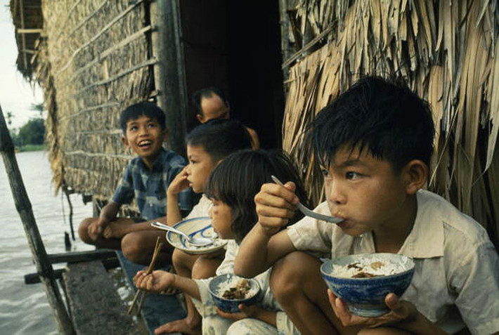 Trẻ em ăn trưa trên một ngôi nhà ven sông ở Cần Thơ.