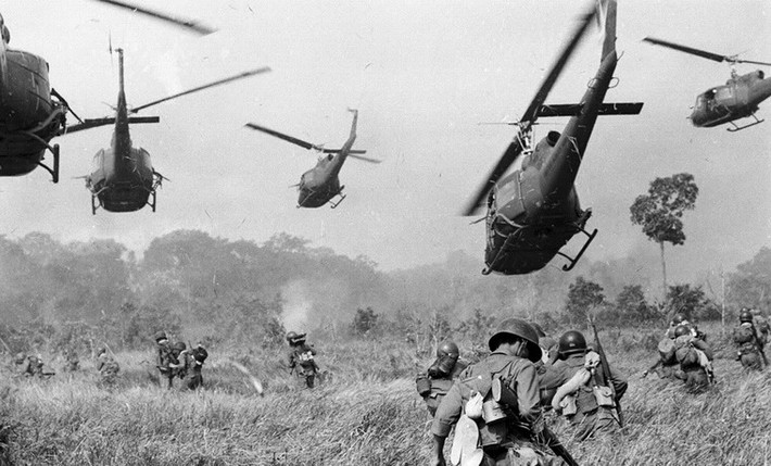 Trực thăng UH-1 của Mỹ nã đạn vào những bụi cây để yểm trợ cho bộ binh chính quyền Sài Gòn trong cuộc tấn công vào một căn cứ của quân Giải phóng tại một địa điểm nằm ở Tây Bắc Sài Gòn, cách Tây Ninh 18 dặm về phía Bắc, gần biên giới Campuchia vào tháng 3/1965. Ảnh: Horst Faas.