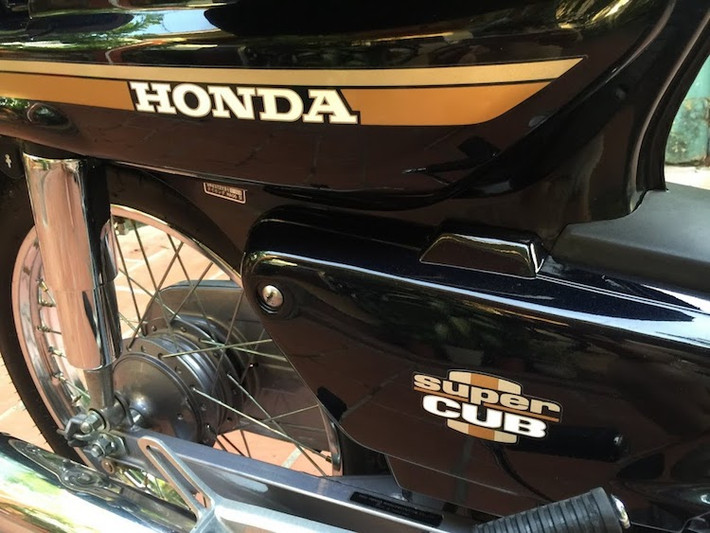 Hai bên thân của Cub Custom 100 được dán tem với thiết kế đơn giản và thiết kế khá giống với những chiếc Cub 82 trước đó.