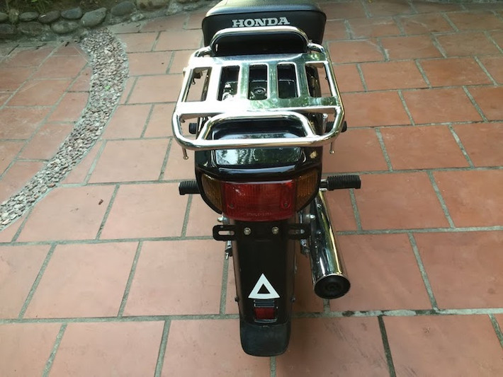 Ngoài khác biệt nằm ở baga, cụm đèn hậu và chắn bùn sau của Cub Custom 100 hoàn toàn không khác gì so với Honda Dream "lùn". Phuộc sau của xe cũng có khả năng điều chỉnh 2 cấp độ.