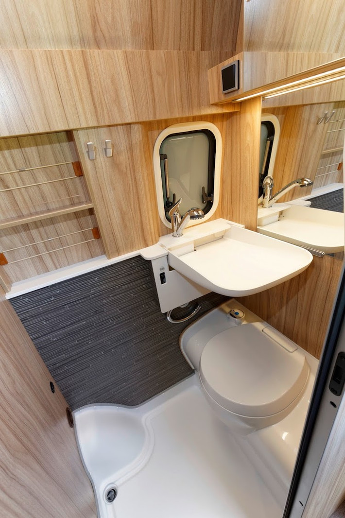 Nằm đối diện với tủ lạnh là toilet của HYMERCAR Grand Canyon S, được bố trí kín trong một diện tích nhỏ chỉ khoảng trên dưới 1m2. Tuy nhiên, toilet này cũng được ốp nhựa cùng gỗ chống nước và có đầy đủ bồn rửa mặt, bồn cầu, bình nóng lạnh, vòi hoa sen và quạt thông gió.