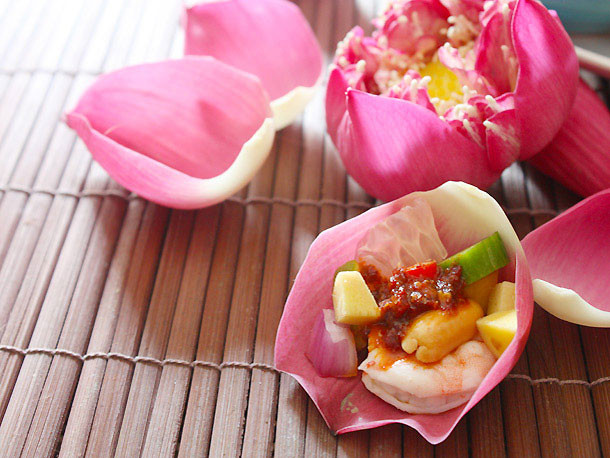 Bày các nguyên liệu nước sốt, tôm, hành, dưa chuột, lạc (hoặc hạt điều), ớt, chanh, bưởi và cánh sen lên đĩa. Món salad tôm này có cách ăn khá đặc biệt: gói mỗi thứ một ít trong lá sen rồi rưới một chút nước sốt lên, cuốn lại và thưởng thức.