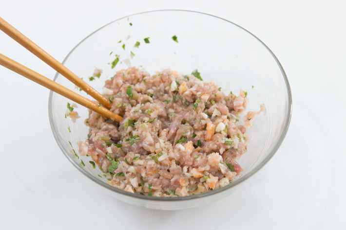 Trộn thịt lợn với lòng trắng trứng, một chút dầu ăn, nước tương, đường, dầu mè, bột bắp, hạt tiêu và để khoảng 20 phút cho ngấm gia vị. Tiếp đó cho củ năng, tỏi, tôm khô, rau mùi vào và trộn đều.