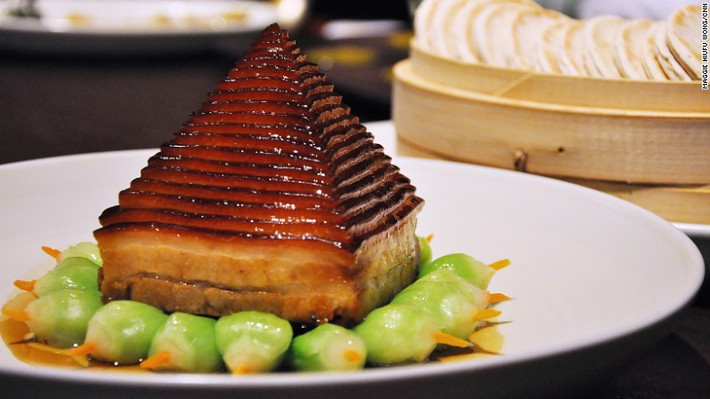 Thịt lợn kim tự tháp Dongpo: Mỗi con lợn chỉ làm được 6 phần ăn như thế này. Thịt ba chỉ được đông lạnh trước khi cắt thành 26 lớp rồi được hấp trong 3 tiếng để mỡ chảy ra khiến miếng thịt mềm nhưng không béo. Bên dưới được trang trí bằng búp măng xanh.