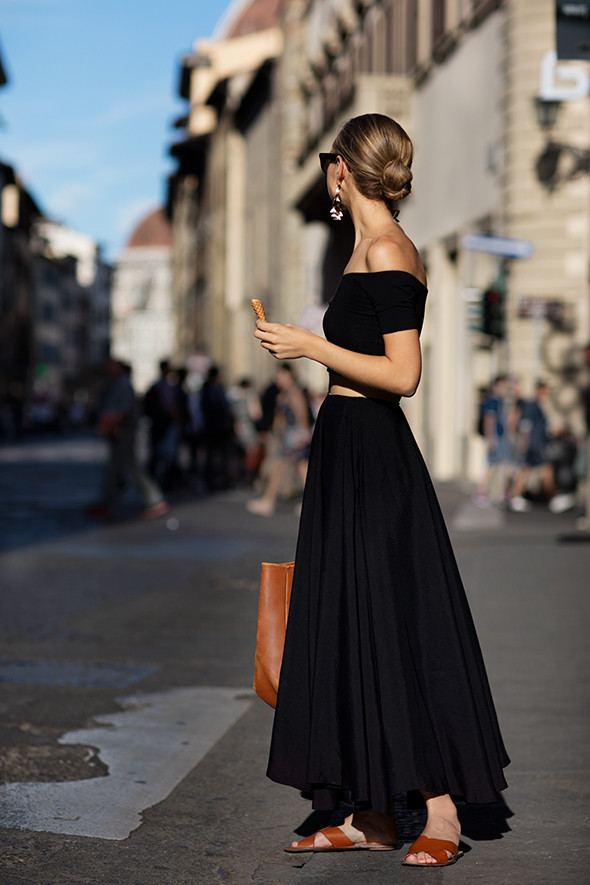 Một cách phối đồ đẹp đến ngạc nhiên: áo croptop trễ vai và váy dài cùng tông màu đen. Bộ trang phục trông đời thường và thoải mái hơn nhờ đôi dép bệt và chiếc túi xách to.