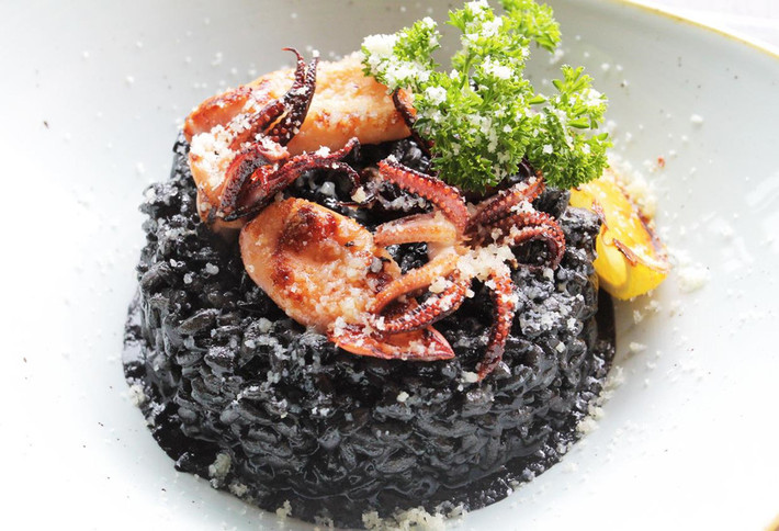 1. Crni Rizot - Black Risotto: Các tín đồ hải sản không thể bỏ qua món ăn này khi đến Croatia. Món ăn đặc sắc của Croatia này có nguồn gốc từ vùng duyên hải của đất nước này. Món này có nguyên liệu từ bạch tuộc, khoai tây, rượu vang, gạo. Màu đen đặc trưng của món ăn là những miếng phô mai cừu béo ngậy. Sau cùng món ăn được rắc phô mai parmesan vụn lên trên cùng. Ảnh: Viettravel.