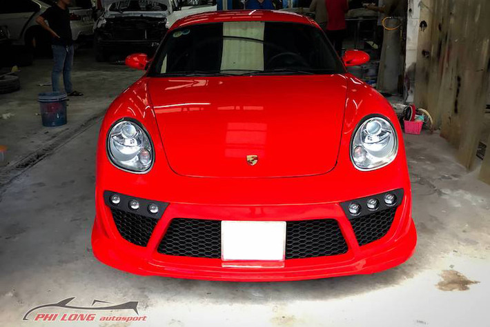 Để khiến chiếc Porsche Cayman đời 2010 của mình trở nên mới mẻ và thể thao hơn, một người chơi xe tại Sài Gòn đã nhờ tới xưởng Phi Long để tạo ra bộ widebody "hàng thửa" cho "xế cưng" của mình. Ở phía trước, bộ cản nguyên bản của Cayman đã được xưởng độ Việt tạo hình lại với các hốc hút gió lớn hơn, cùng với dàn đèn chiếu sáng tăng cường dạng bi cầu nằm đối xứng hai bên.