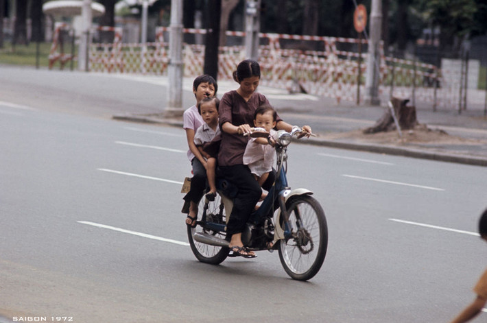 Bà mẹ trẻ chở ba đứa con nhỏ trên chiếc xe gắn máy. Ảnh: Patrice Habans.