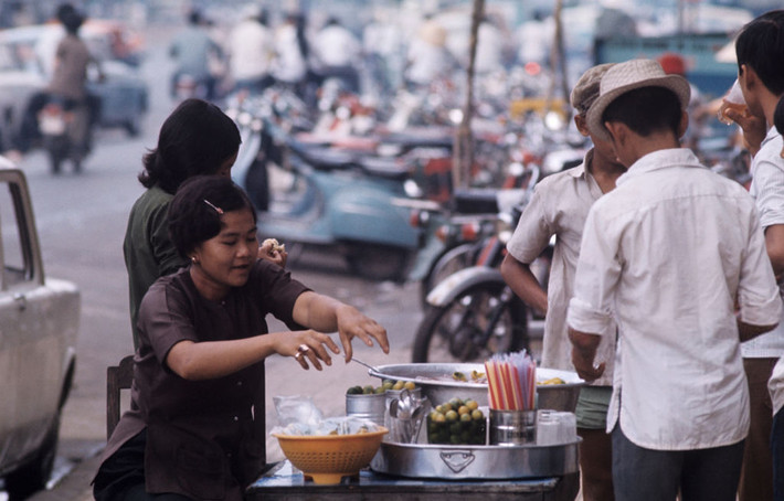 Những người đàn ông tụ tập trước quầy giải khát vỉa hè của hai thiếu nữ. Ảnh: Patrice Habans.