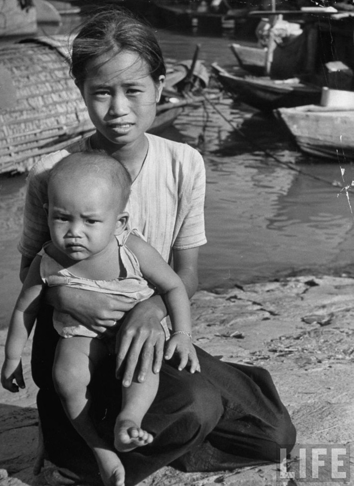Bà mẹ và cậu con trai kháu khỉnh bên bến sông. Ảnh: Carl Mydans/ Life.