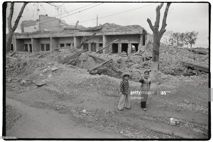 Hai em bé đứng gần một khu nhà đổ nát ở Hà Nội ngày 1/1/1973. Các cuộc ném bom vừa chấm dứt một ngày trước đó.