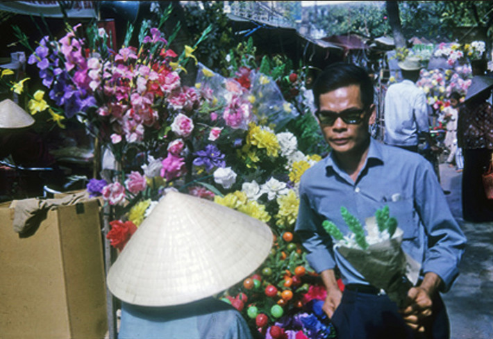 Sắc màu của các quầy hoa giấy khiến khu chợ Tết trở nên rực rỡ. Ảnh: Vietnam Center and Archive.