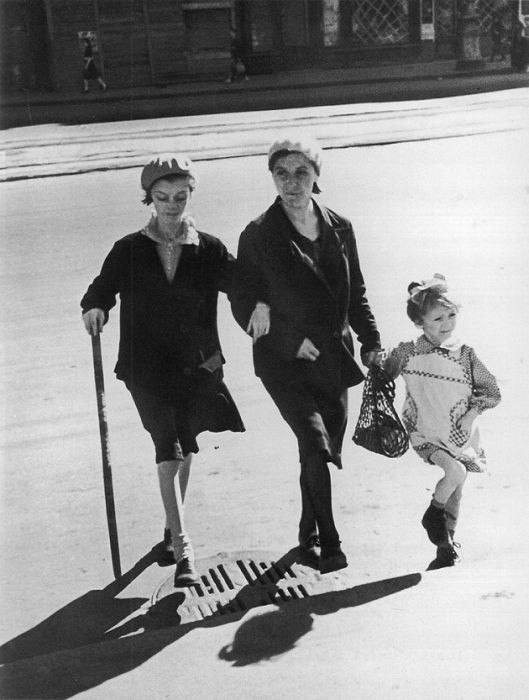 Ba mẹ con trên đường phố Leningrad tháng 5/1952. Một người con gái phải chống gậy do suy kiệt vì thiếu thực phẩm. Ảnh: Englishrussia.com.