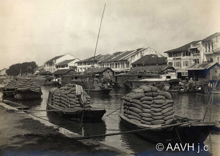 Những con thuyền chở gạo neo đậu bên bờ kênh Tàu Hủ ở Chợ Lớn năm 1925. Ảnh: AAVH.