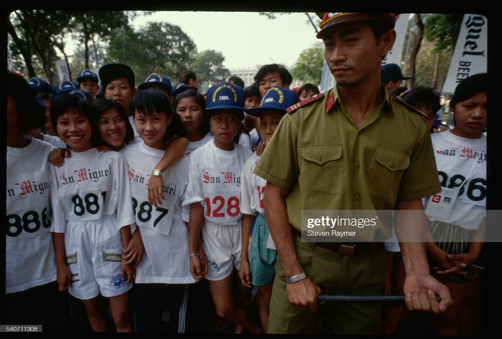 Một cảnh sát giữ người chạy ở vạch xuất phát của cuộc thi Marathon Quốc tế TP. HCM.
